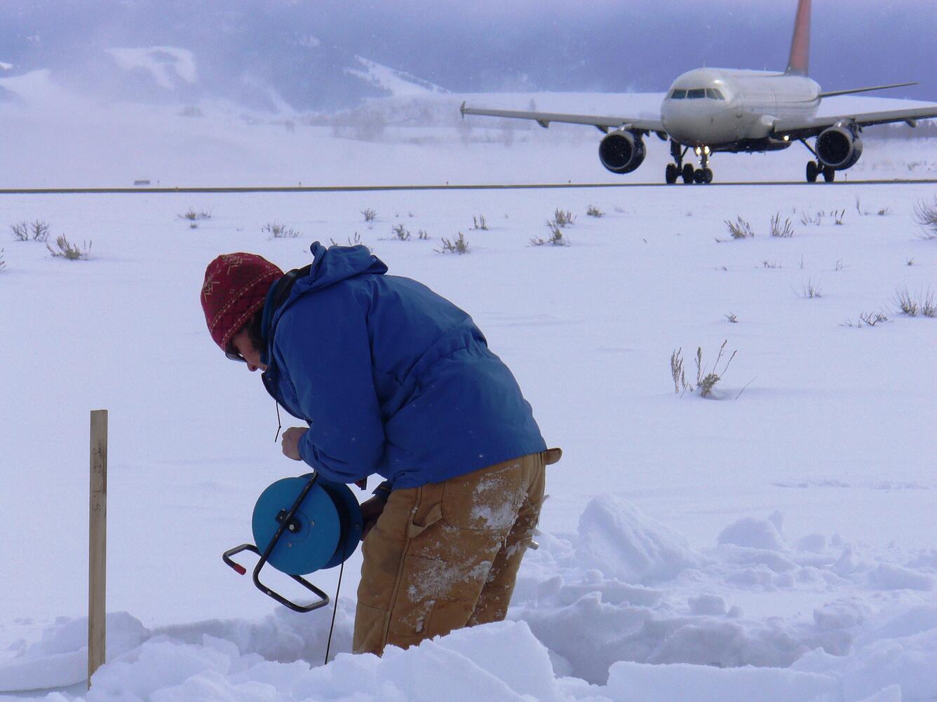 Taking a water-level measurement in a monitoring well at Jackson Hole Airport