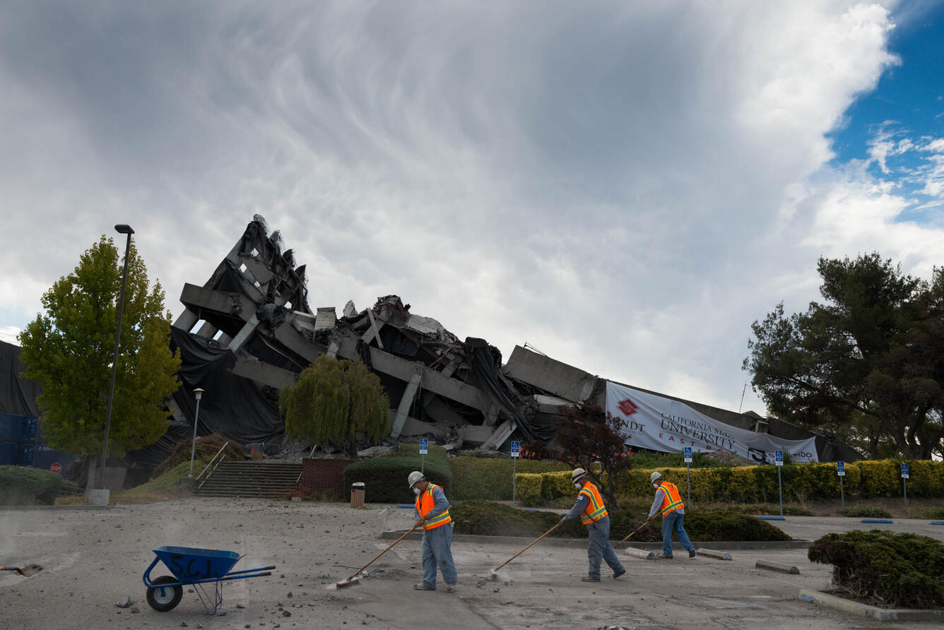 Workers begin cleaning up debris moments after the implosion of Warren Hall.