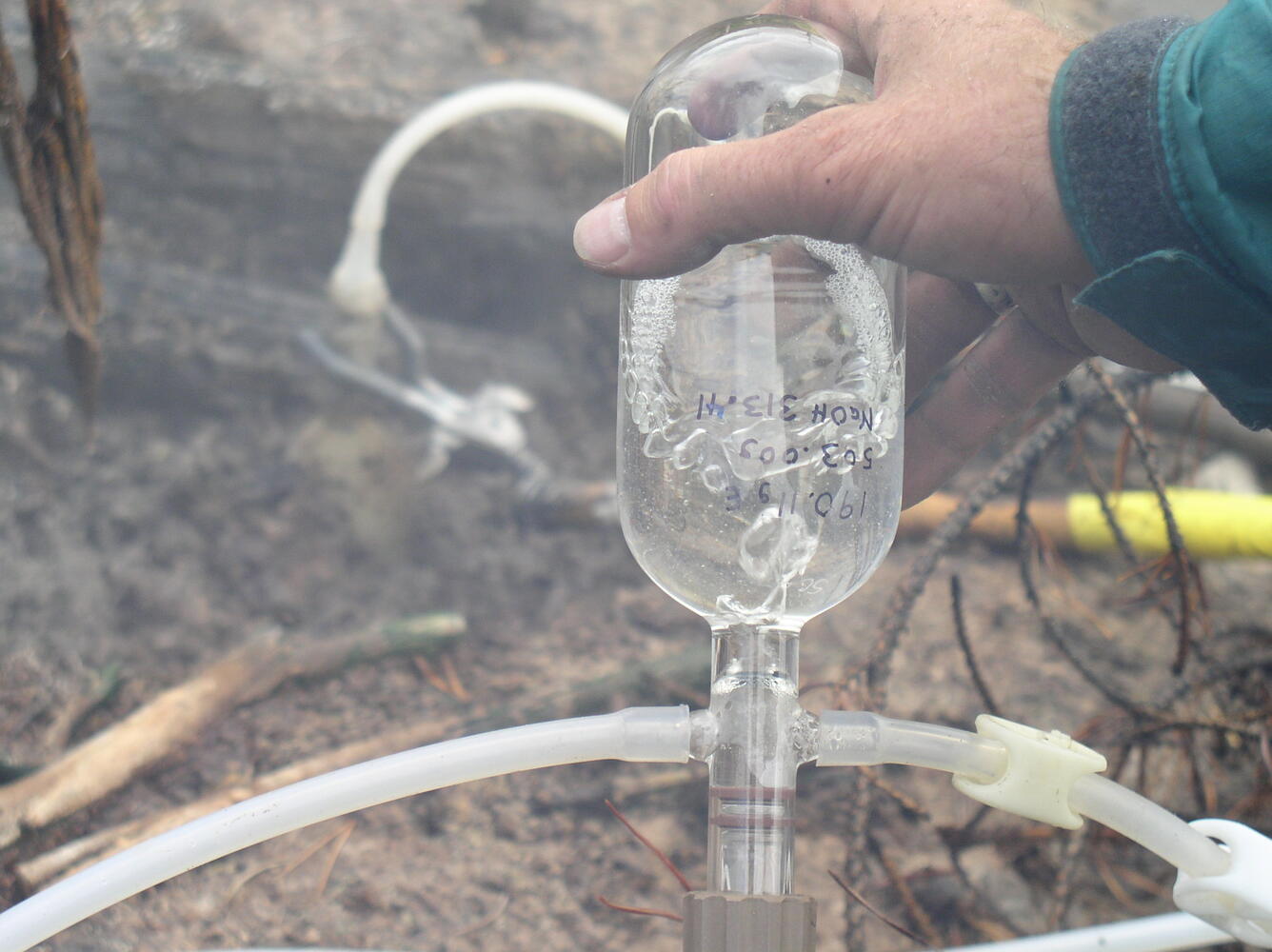 Gas sample being collected in a glass bottle