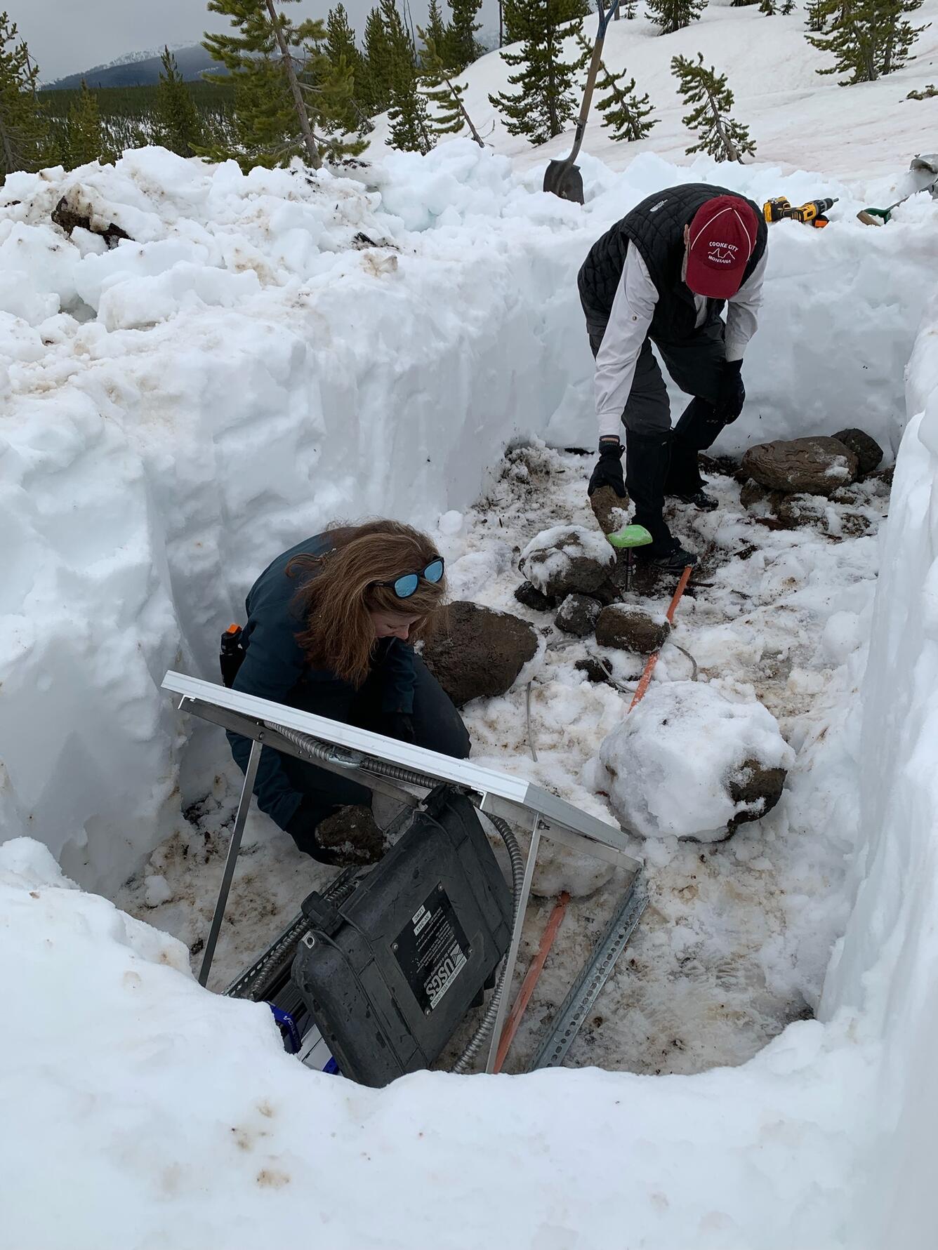 Scientists digging a hole in snow to install semipermanent GPS station Yellowstone