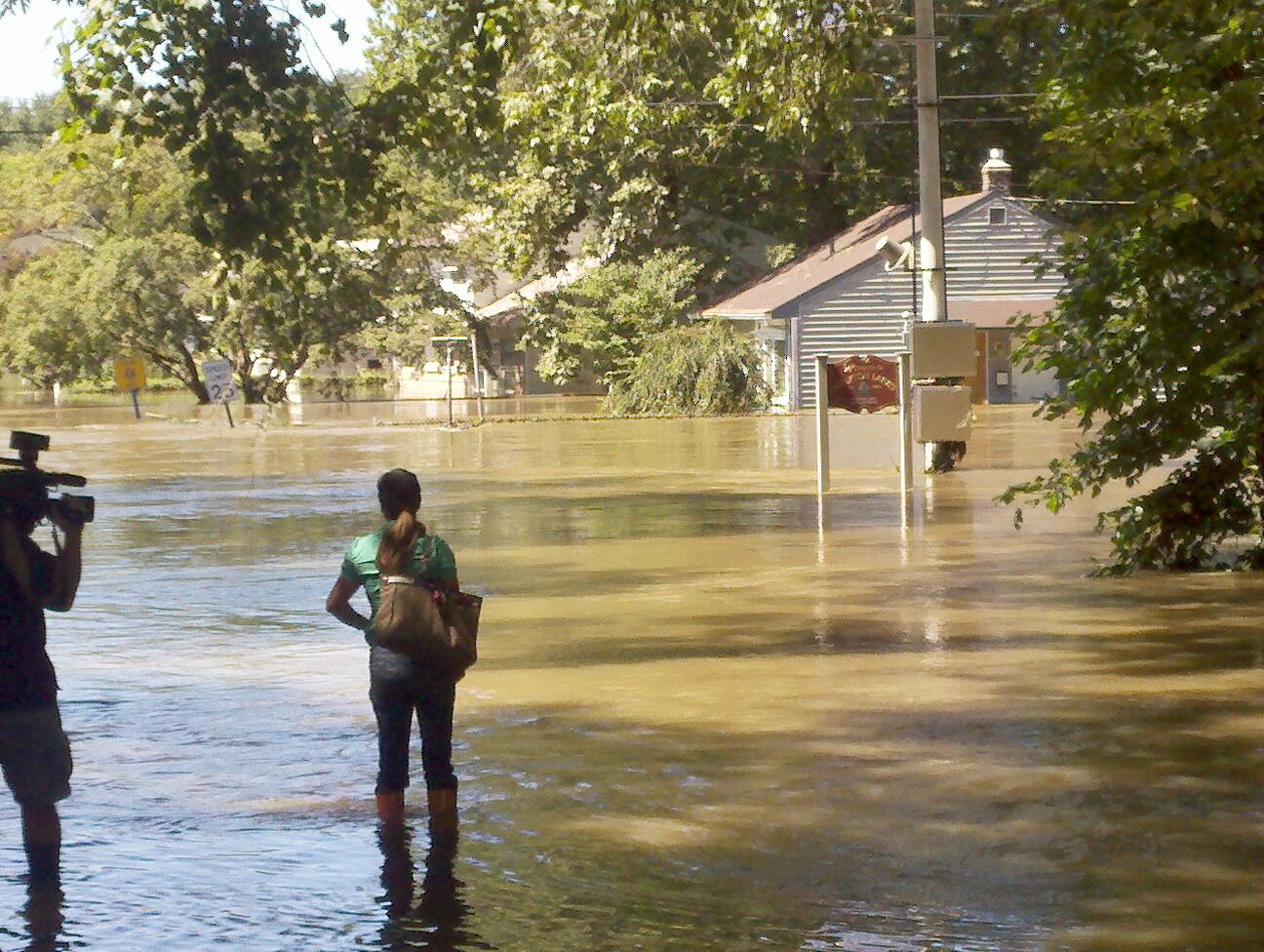 Reporters filming flood damage