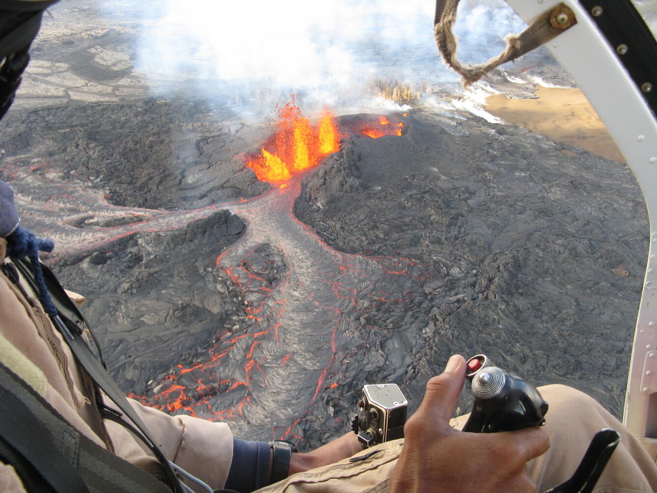 Eruption of Kīlauea Volcano visible through the cockpit of a small helicopter