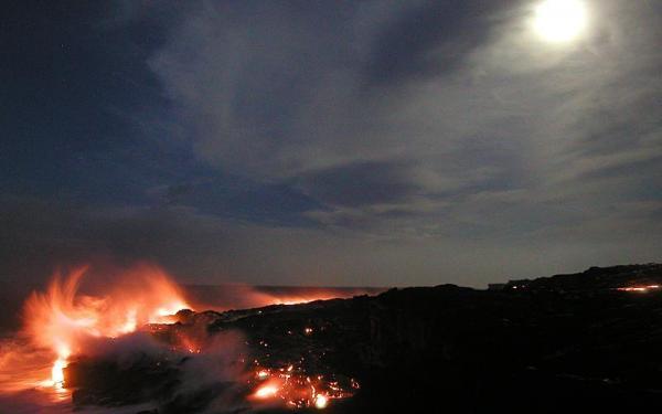 Lava cascades down sea cliff and moves across bench