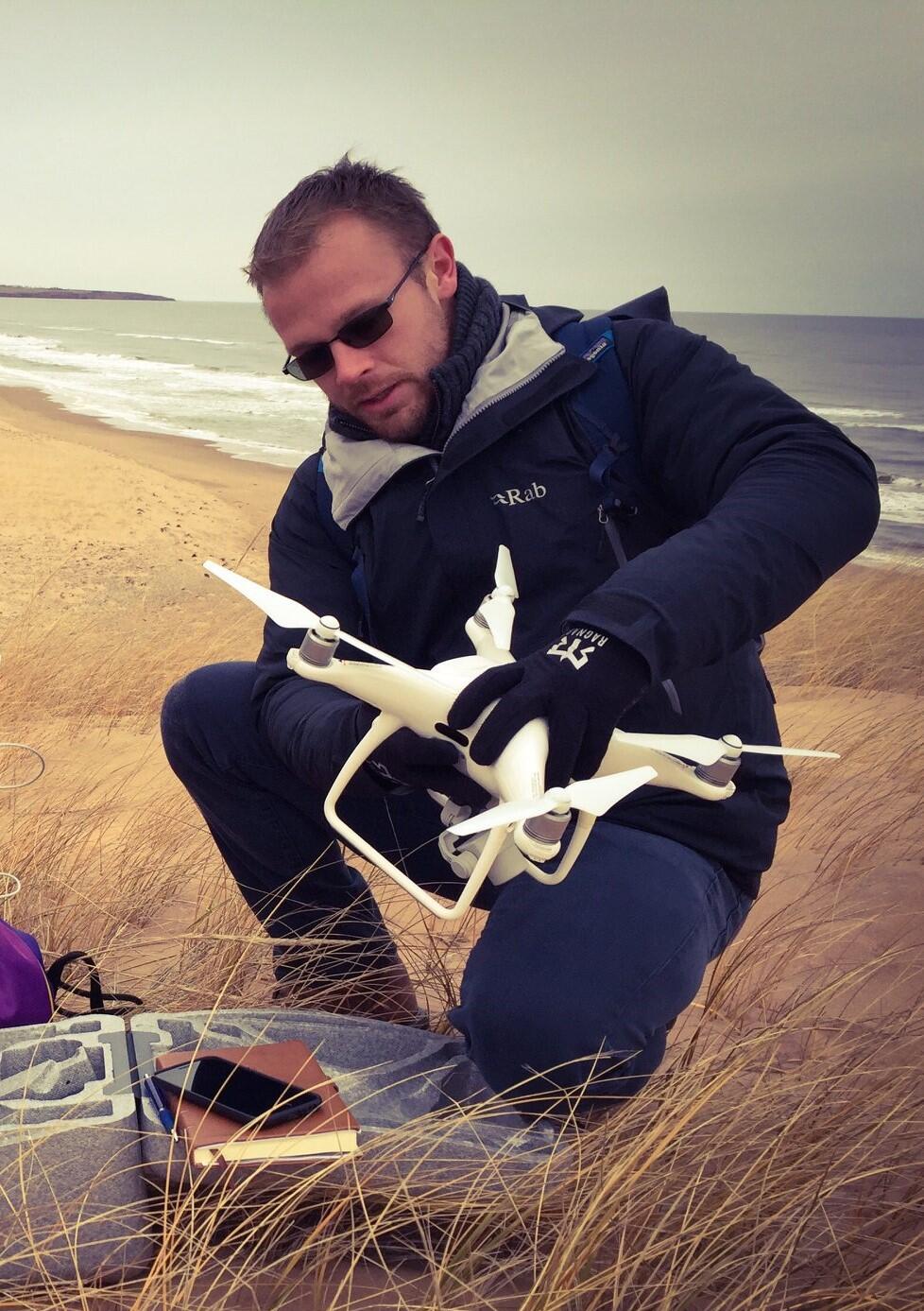 photo of Phil with a drone on top of a sand dune