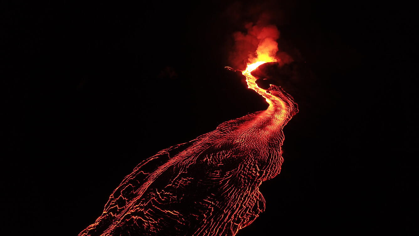 Lava flowing out of a fissure at night