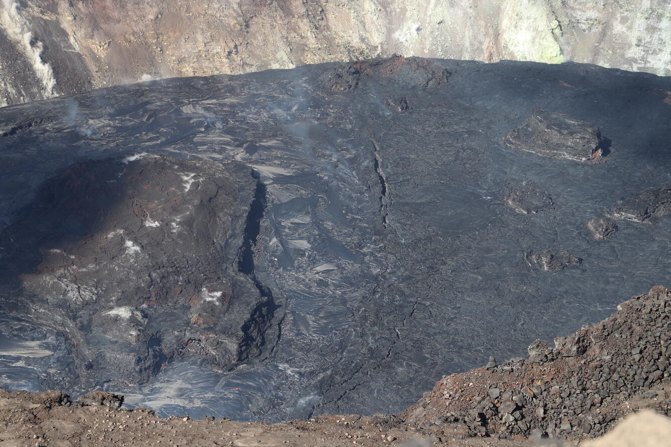 A north-south trending line of surficial cracks divides the boundary between the active western and inactive northern lava lake