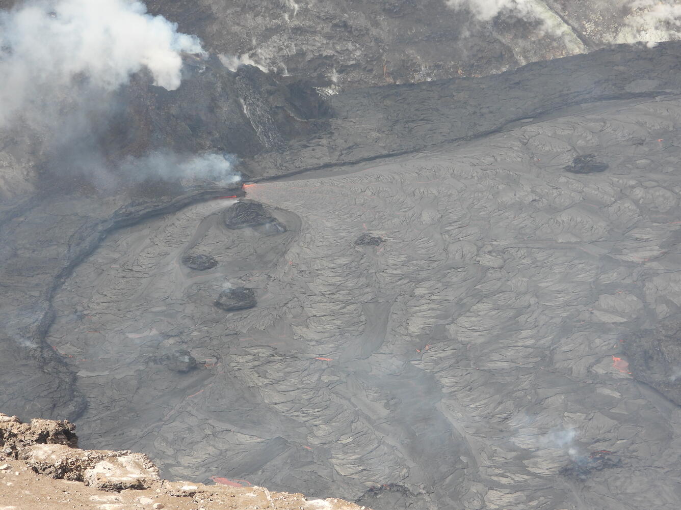 Color photograph of volcanic vent,  lava lake, and islands