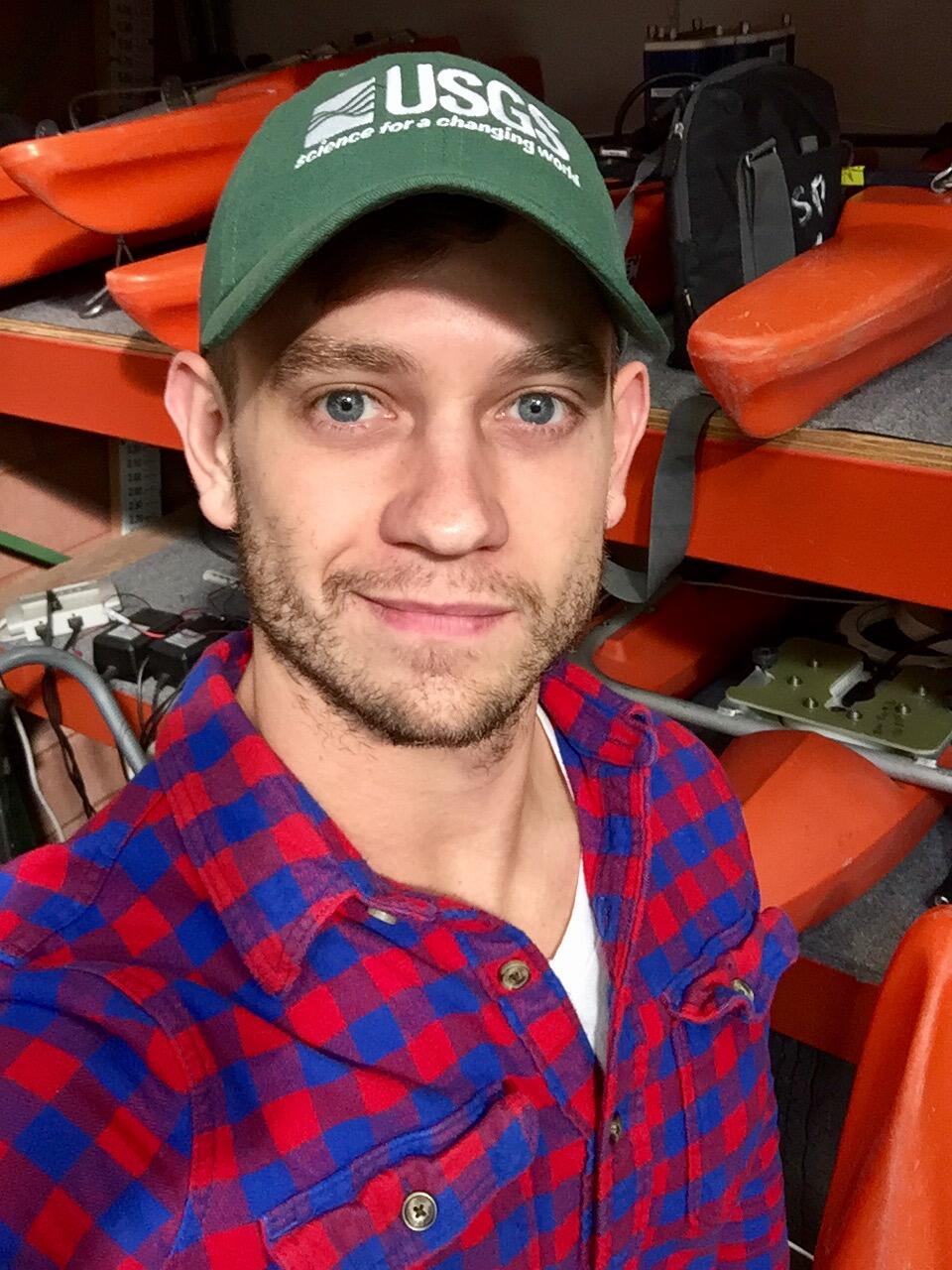 Self portrait of Hydrologic Technician, Adam Baldwin, standing in front of devices that measure streamflow.