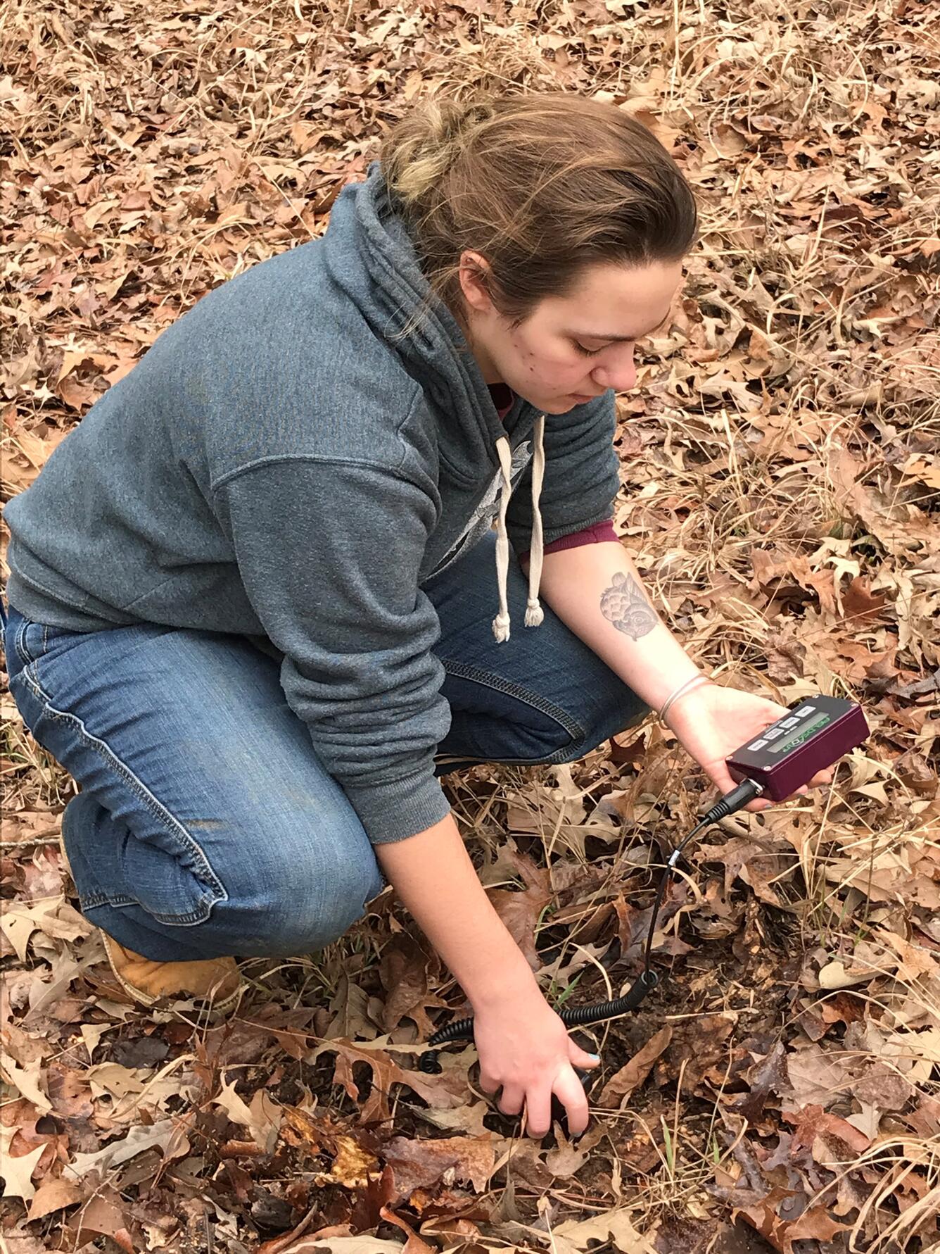 Natasha Drotar measuring soil moisture.