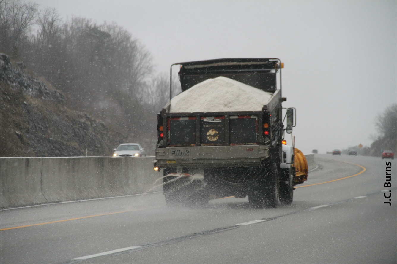 Truck distributing road salt on a highway