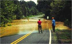 Rising floodwaters overtopping a local bridge. Charlotte-Mecklenburg Hydrologic Network