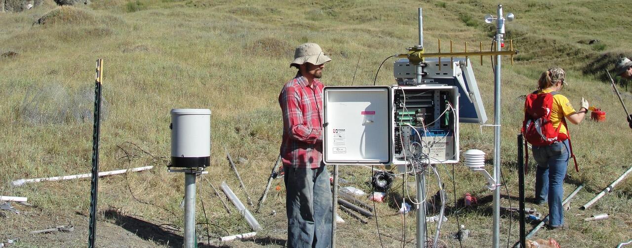 scientists in a field with landslide instruments