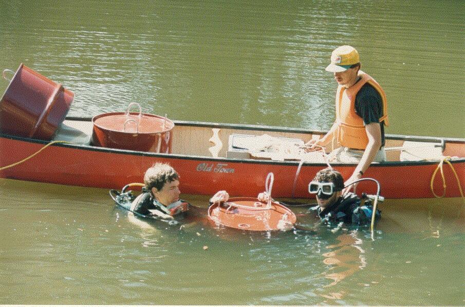 Stewart Rounds (in canoe) and USGS SCUBA divers Jim Caldwell (left) and Ken Skach-Mills (right) deploying seepage meters.