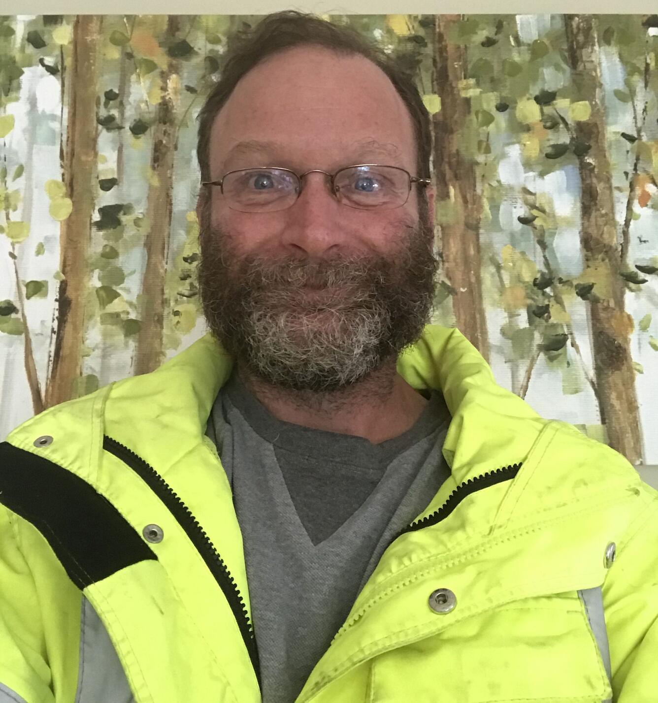 man with beard and glasses in neon green coat 
