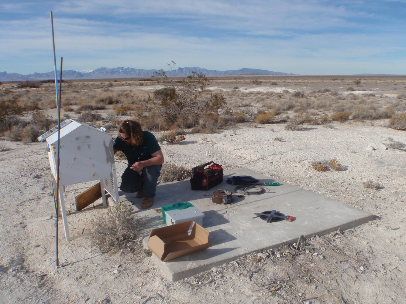 USGS scientist installing a transducer at well TW-3, Nev.