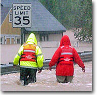Hydrologists walking on a flooded road