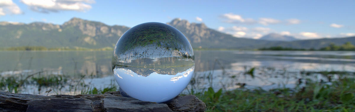 A glass sphere showing a lake through it
