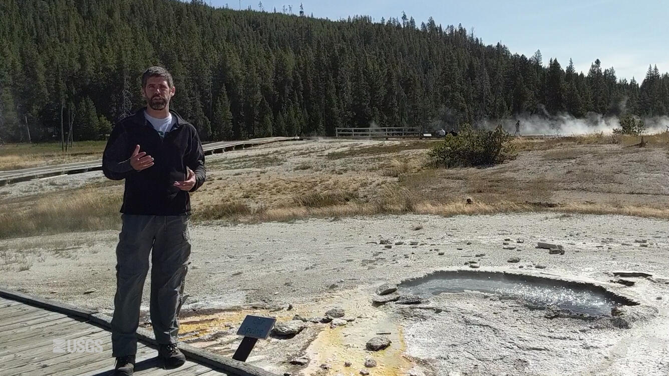 Man standing next to a geyser