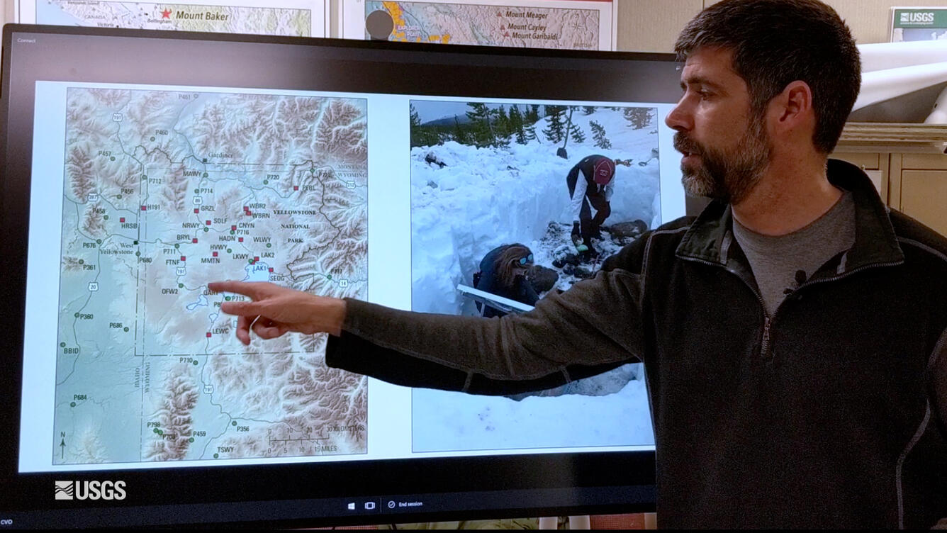 Man pointing to a map Yellowstone on a TV screen