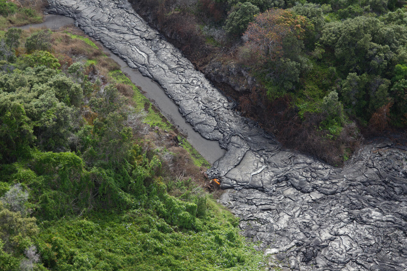 About one month ago, lava spilled westward through this roadcut alo...