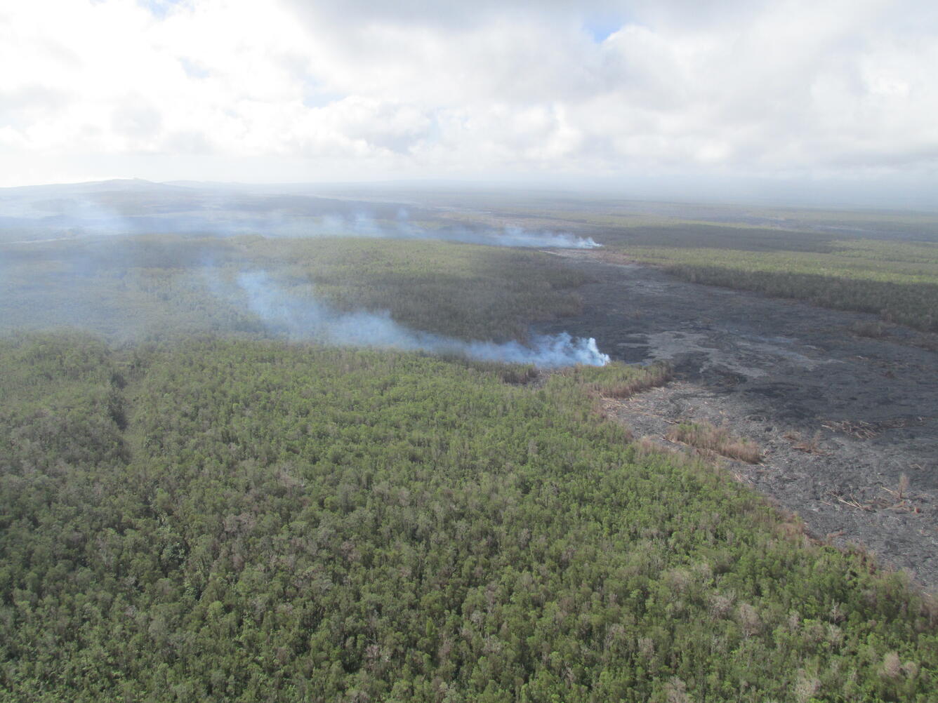 Burning vegetation at breakouts along margins of flow about mid-way...