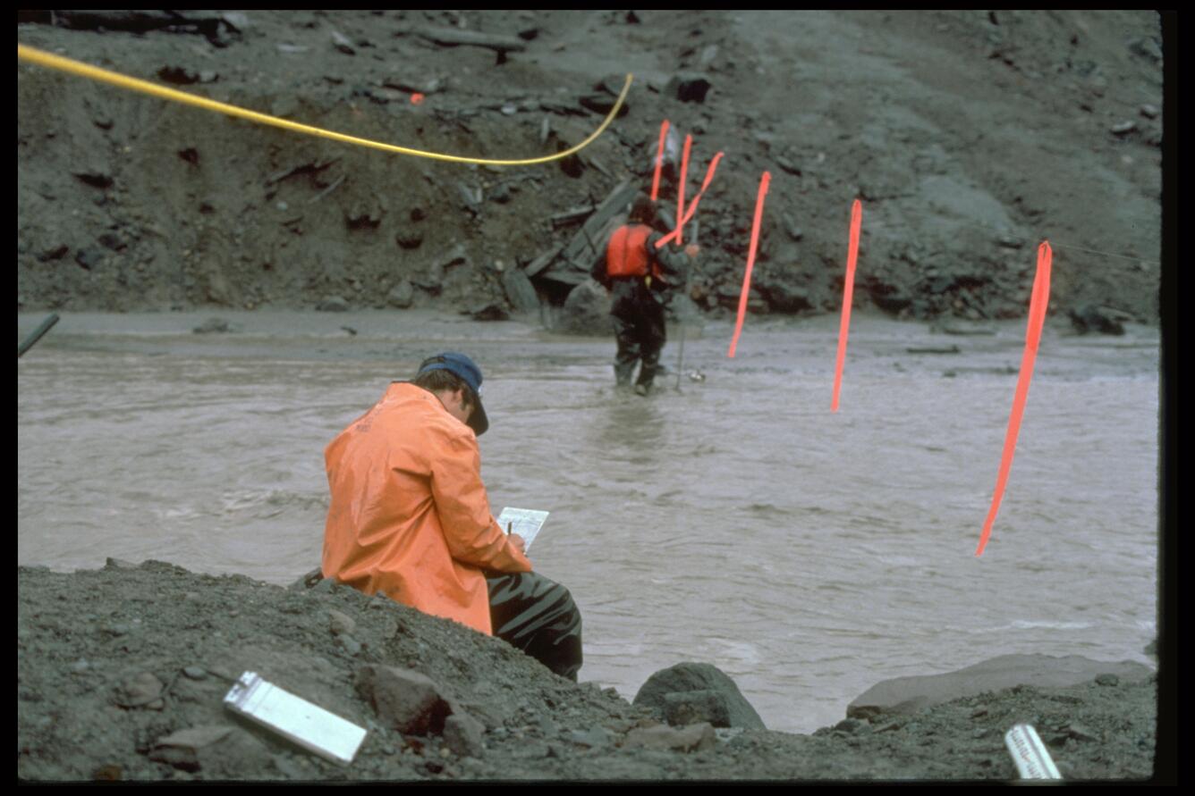 Hydrologists measuring stream discharge and took water samples to d...