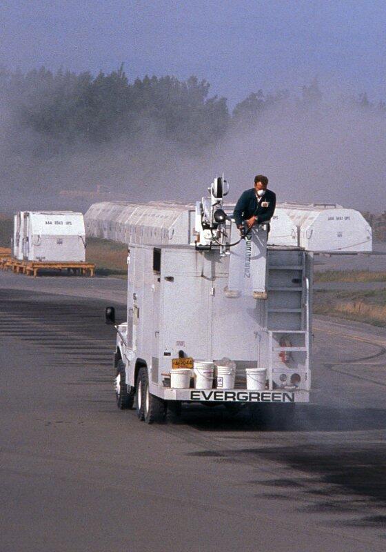Water truck saturates ash covered runway at Anchorage International...