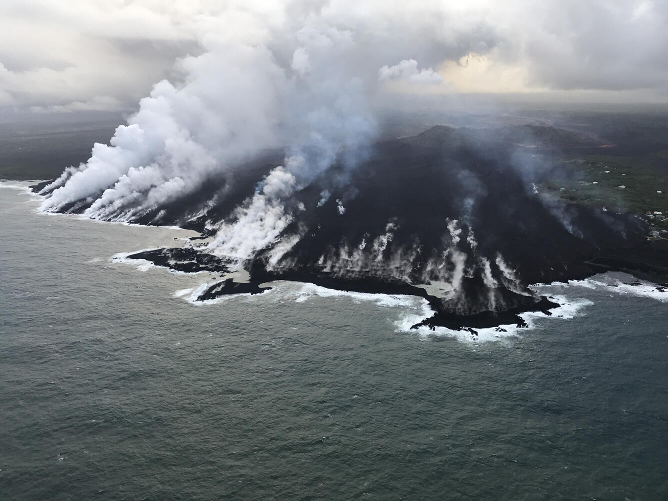 Helicopter overflight of ocean entry at KAPOHO Bay. Lava is buildin...