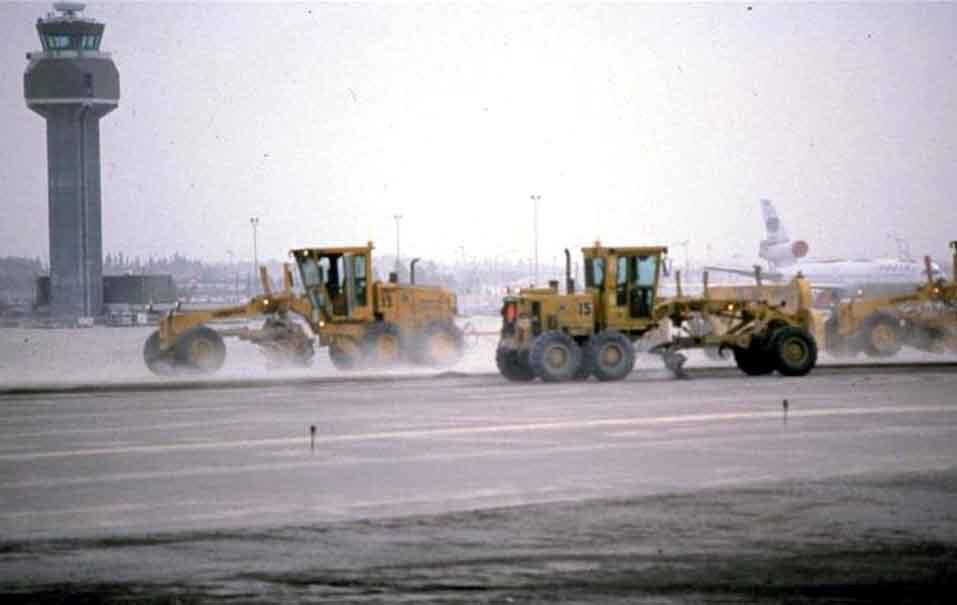 Graders clean minor ashfall from the Anchorage airport following Mo...