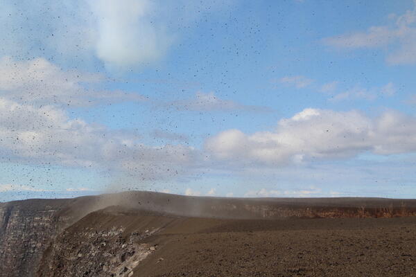 Color photograph of falling volcanic tephra