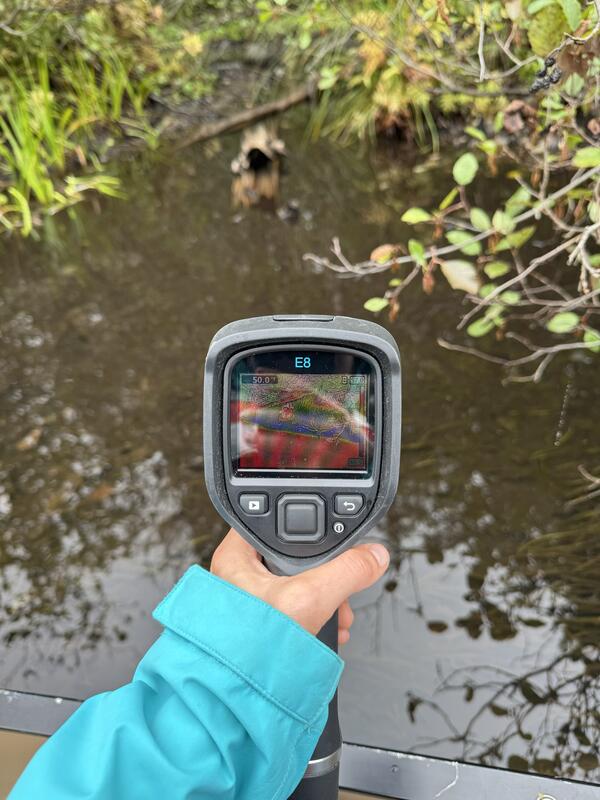 A close up of a handheld device pointed at a river.