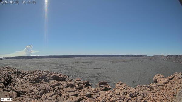 Color photograph showing a volcanic plume rising in the background of a volcanic caldera
