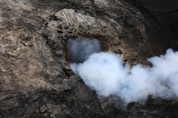 Volcanic vent emitting a thick white volcanic gas plume
