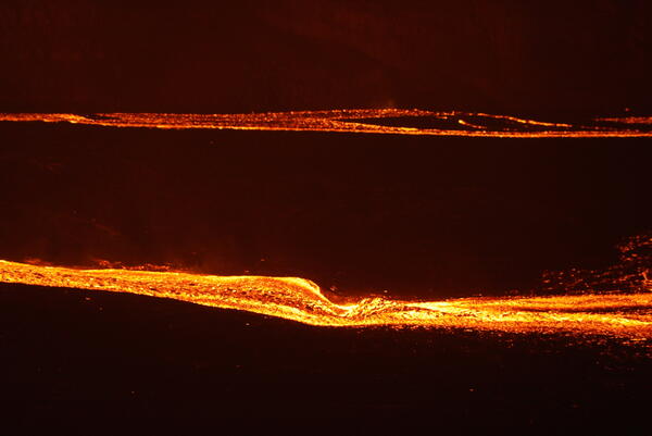 Color telephotograph of lava streams at night