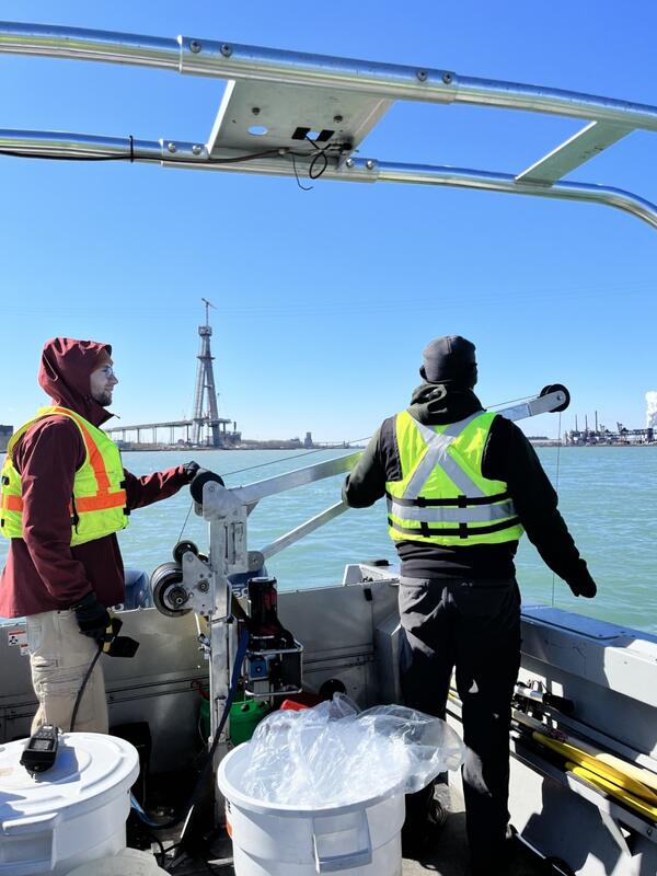 Scientists operate water quality sampling equipment from a boat on the Detroit River, Michigan