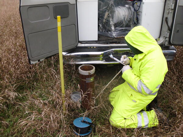 Image of man in hiviz gear taking measurements