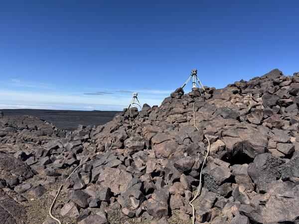 Color photograph of volcano monitoring equipment on lava flows