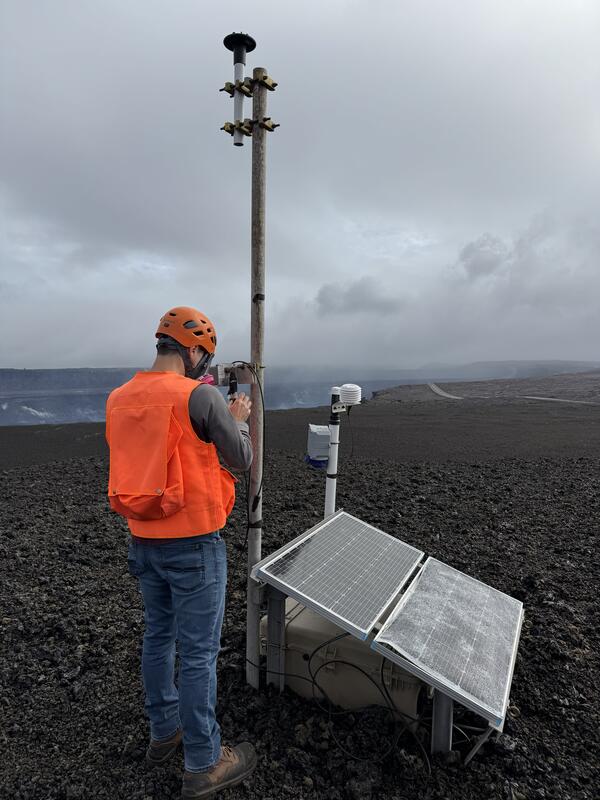 Color photograph of scientist checking monitoring equipment
