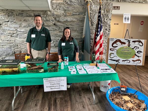 Two USGS employees with an exhibit about amphibians