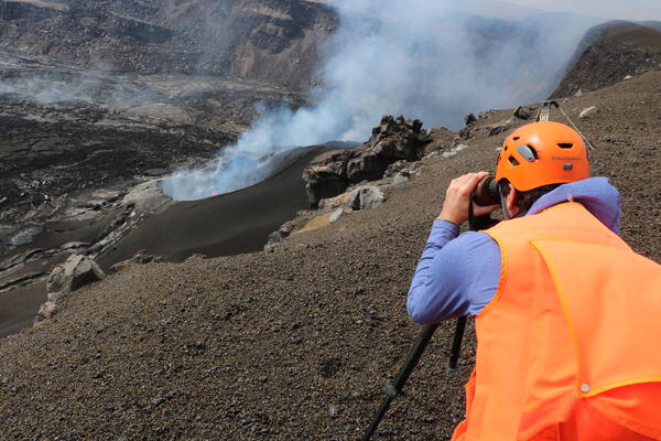 Color photograph of scientist monitoring eruption