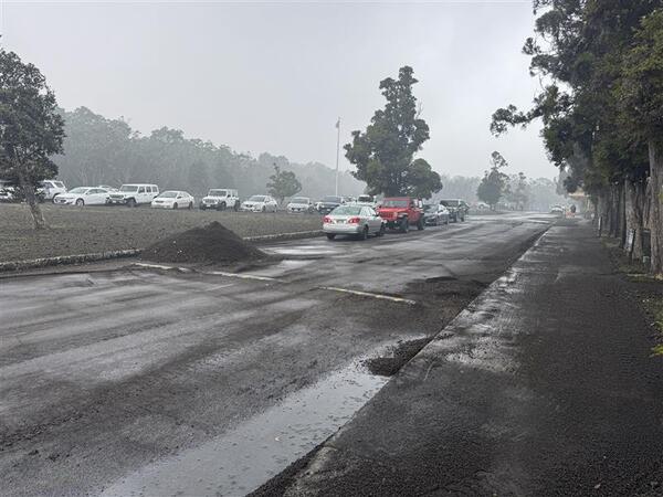 Color photograph of a pile of volcanic fallout that was cleared from roadway