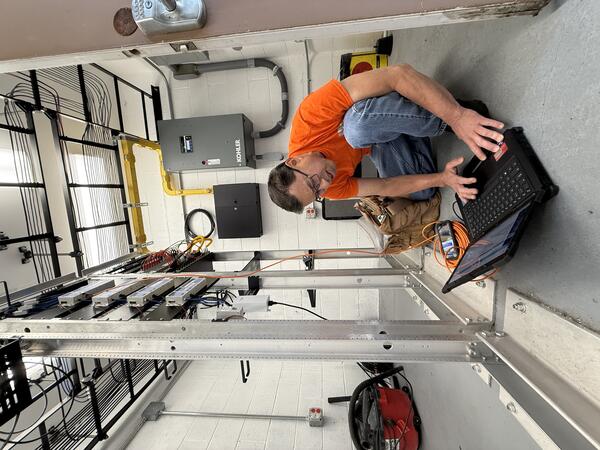 Color photograph of field engineer checking laptop