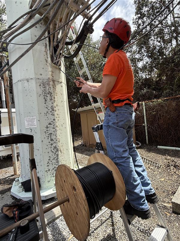 Color photograph of field engineer checking cables