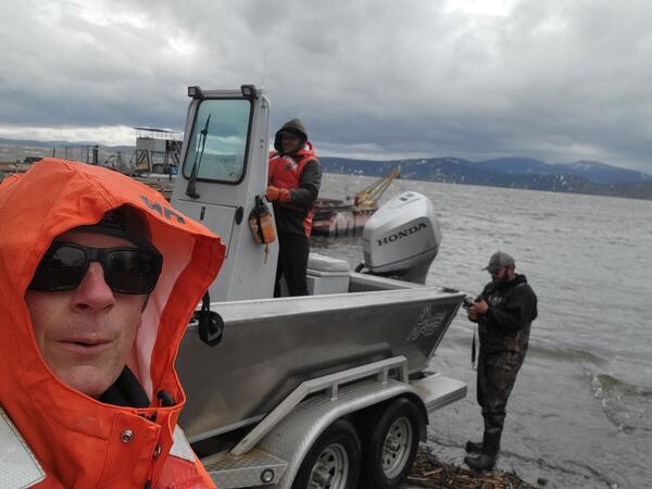 Selfie with man in orange hood and boat with two men in background on Upper Klamath Lake, Klamath Falls, OR