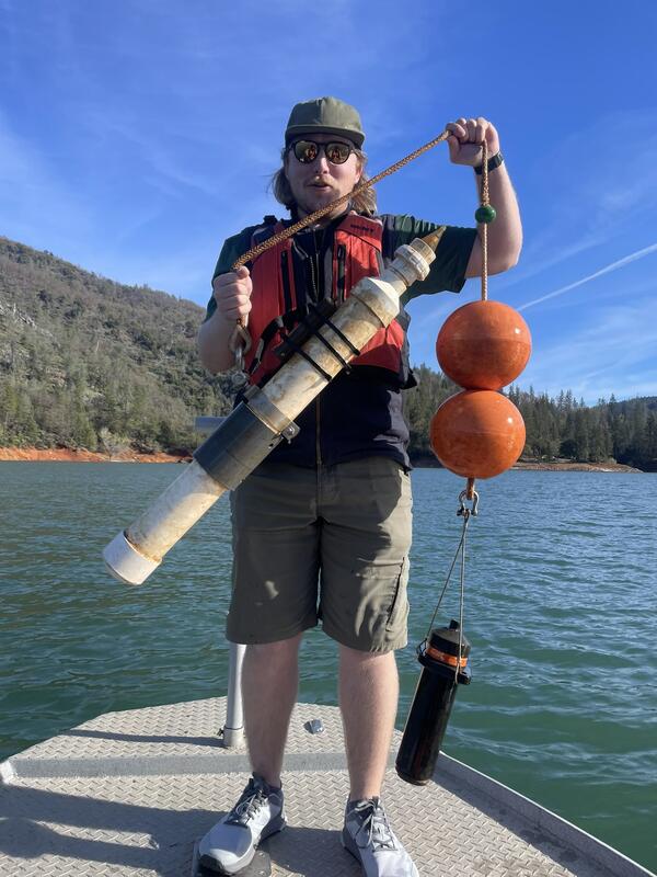 Man standing on boat holding telemetry receiver 