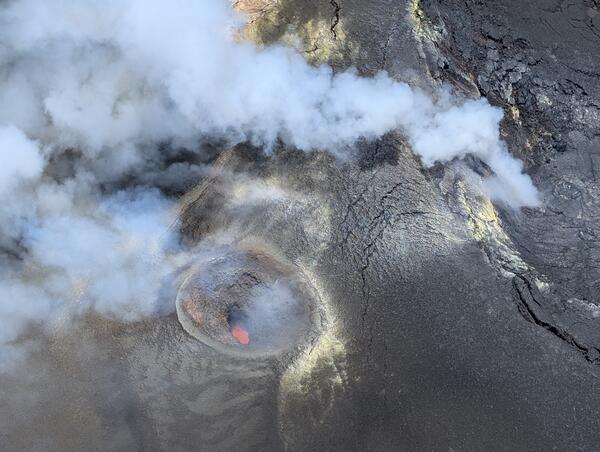 Color photograph looking down into a volcanic vent with magma visible inside it