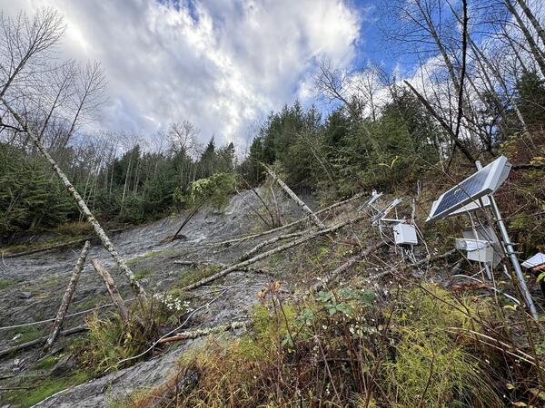 equipment on hillside that is covered with dirt and trees