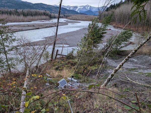 equipment on hillside next to trees above river