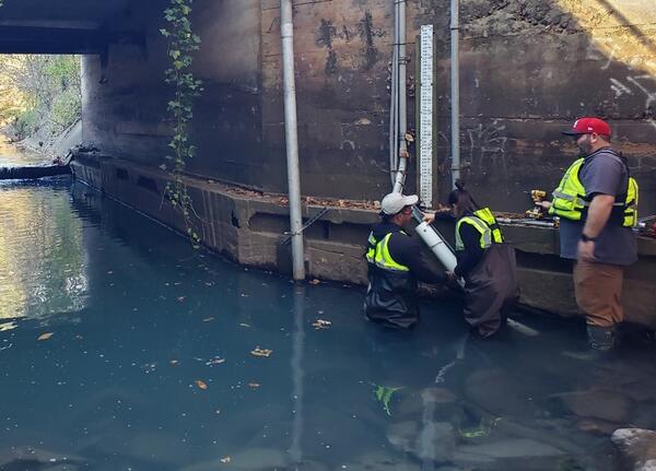 Scientists installing sensor in river