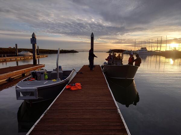 Photo of RV Williams at sunrise tied up to a dock with researchers aboard